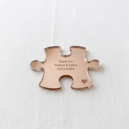 Rose gold puzzle piece pendant with engraved text on a white background