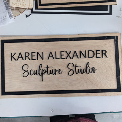 Business name Karen Sculpture studio  wooden sign with black acrylic on a white background 