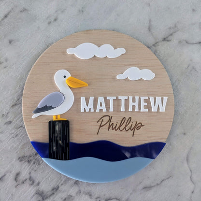 Round wooden sign with a pelican illustration personalised for nursery
