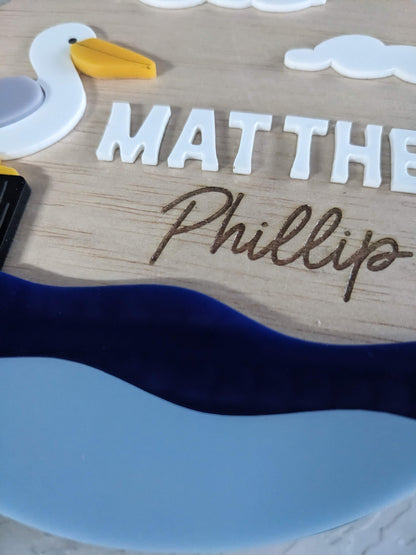 Wooden plaque with a seagull design and engraved names on a white background
