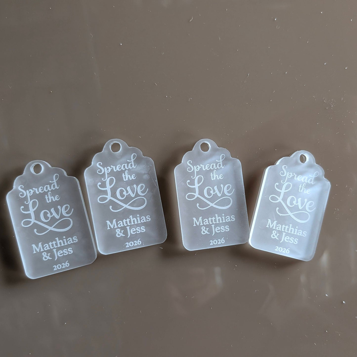 Four clear tags with engraved text for wedding favour