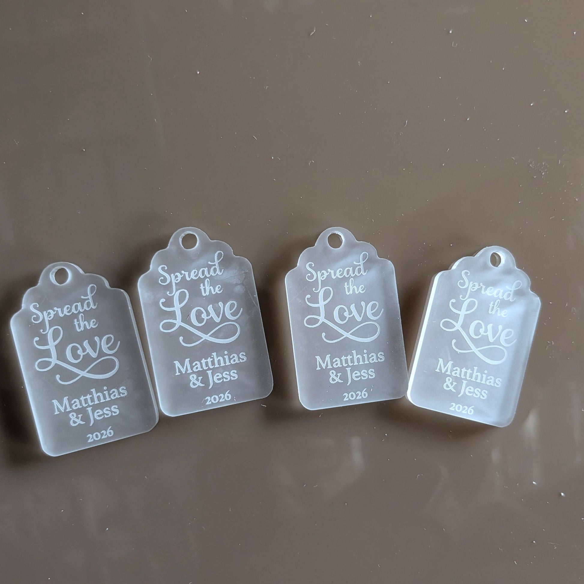 Four clear tags with engraved text for wedding favour