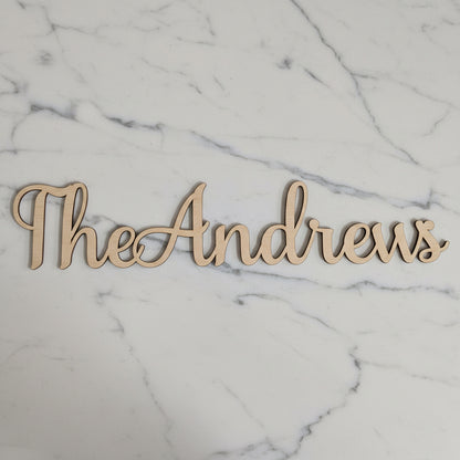Personalised wooden name sign for a wedding, cut in script font from natural plywood