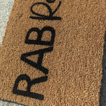 Doormat with 'RAB Resort' printed on it on a concrete surface