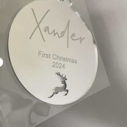 Round silver ornament with 'Xander' and 'First Christmas 2024' engraved, on a light gray background.