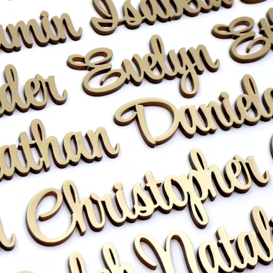 Wooden nameplates with various names engraved on a white background