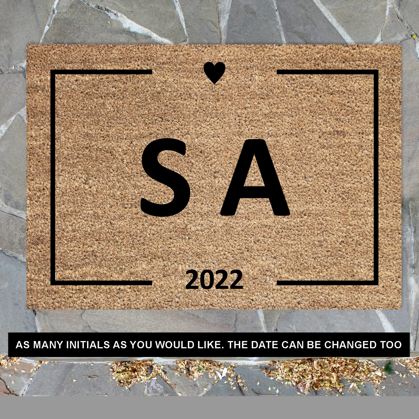 A customised rectangular coir doormat with black initials a small heart, and the year '2026