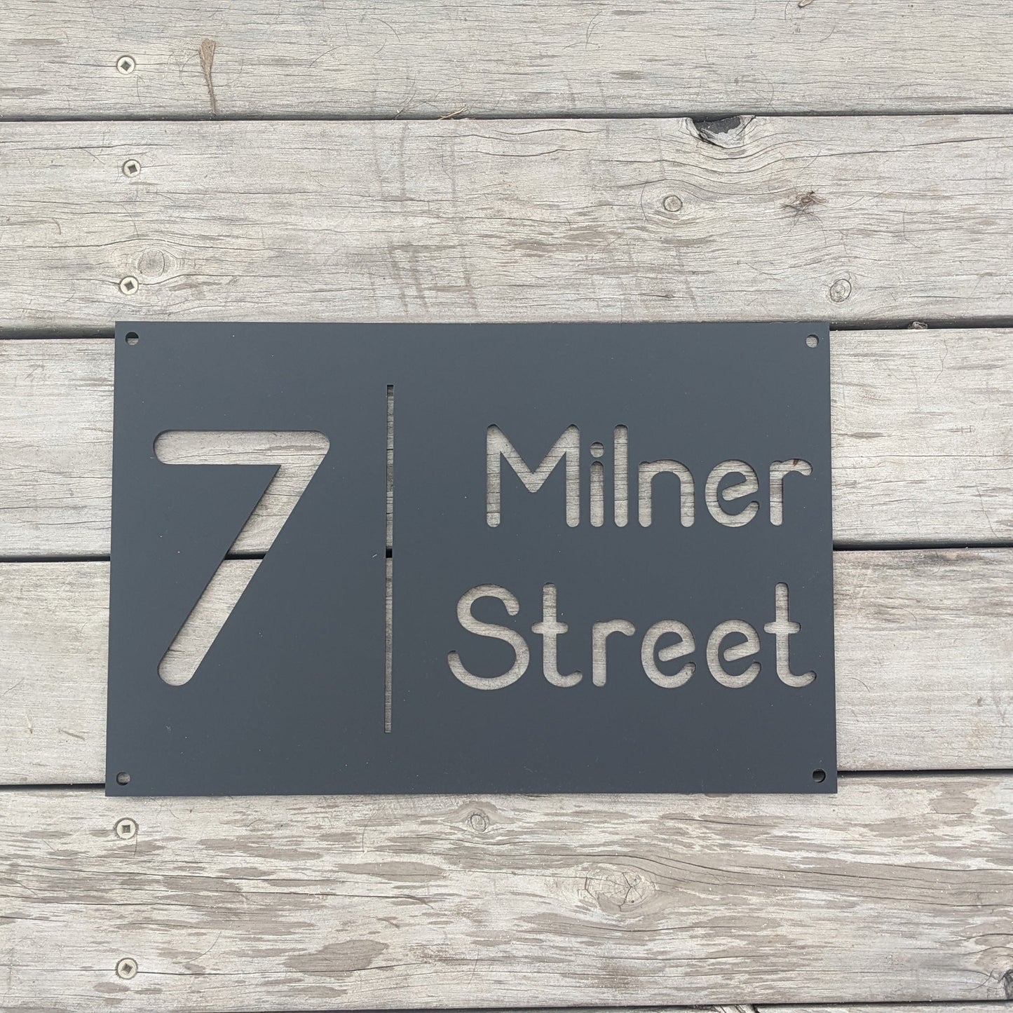 Black house number sign on a wooden background