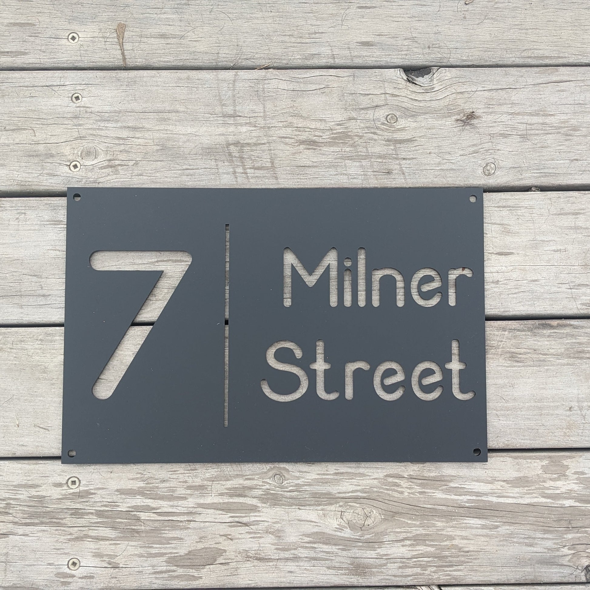 Black house number sign on a wooden background