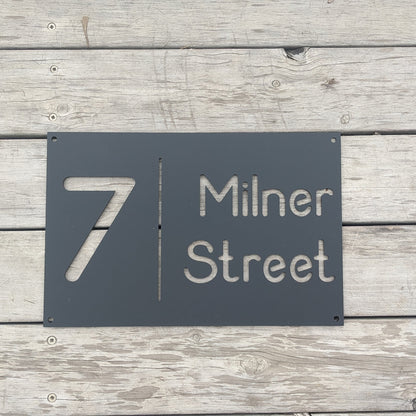 Black house number sign on a wooden background
